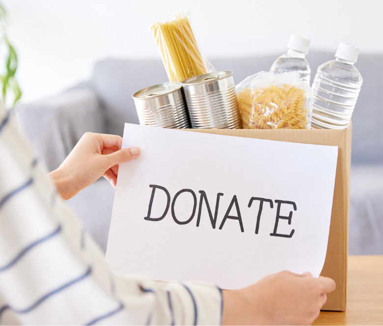 A box of donated food items including water, canned food and pasta.