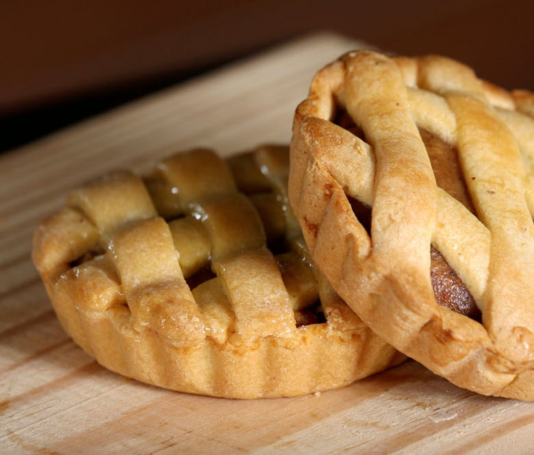 Mini apple pies on a cutting board.