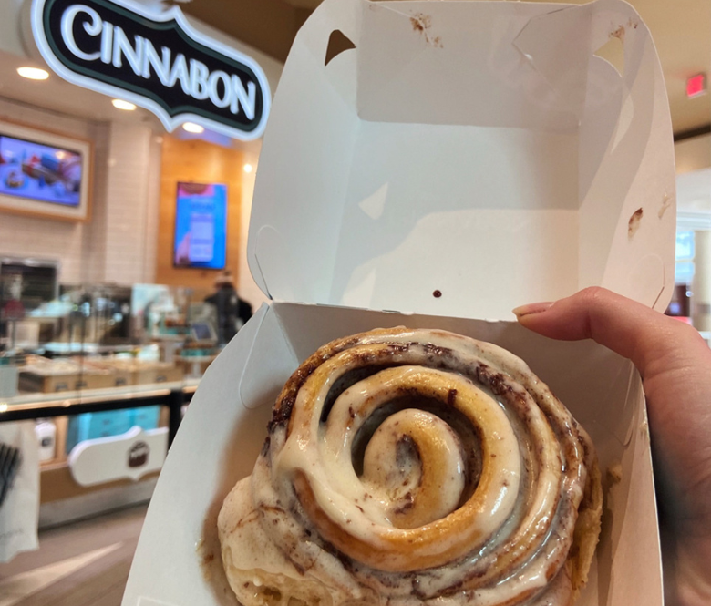 A cinnamon roll inside of an open box.