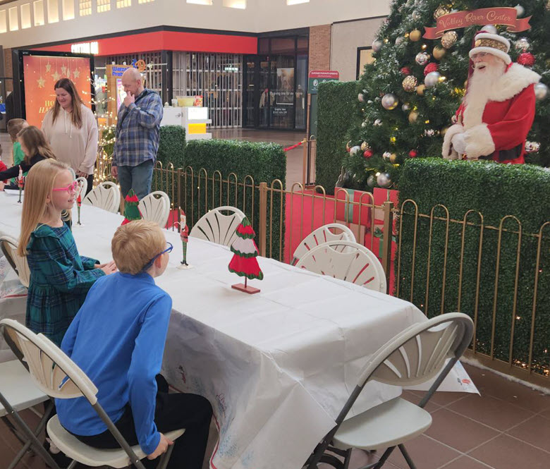 Kids sitting at a table waiting to greet Santa.