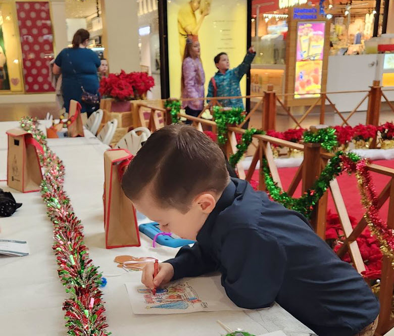 A young boy coloring at the table. 