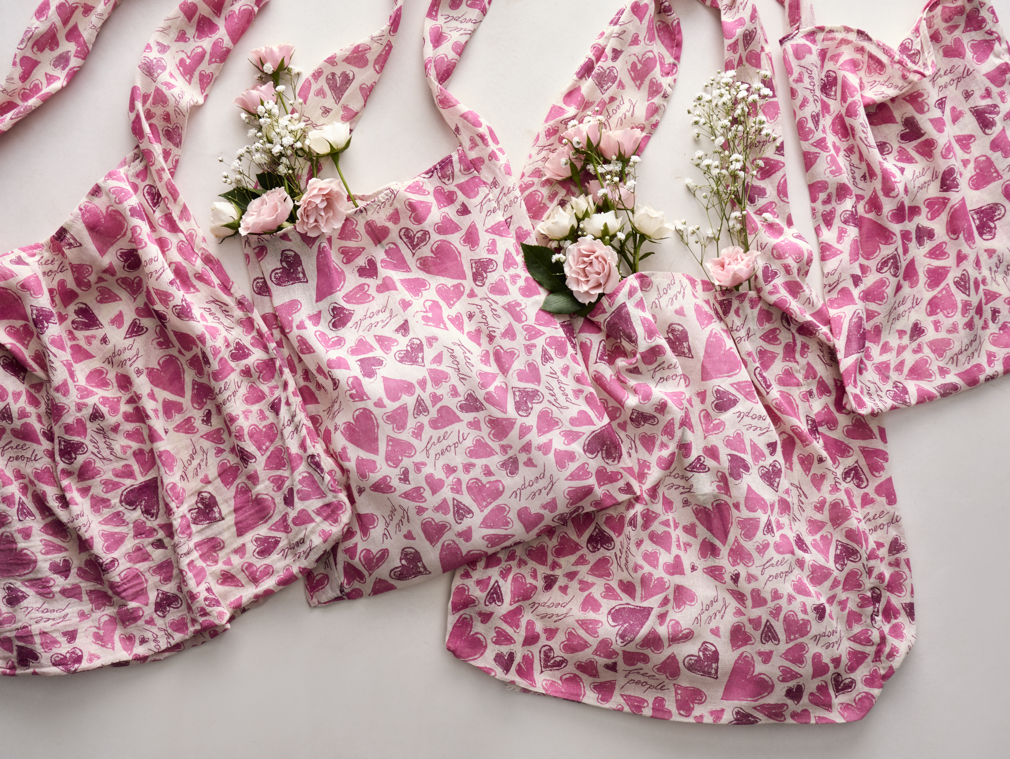 Pink and white Free People bags with hearts on them