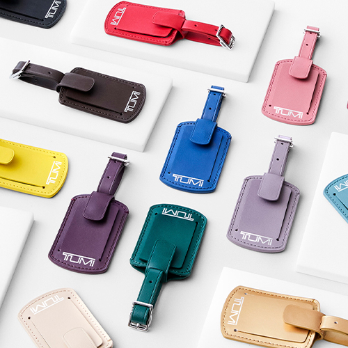 All colors of TUMI luggage tags on a white table