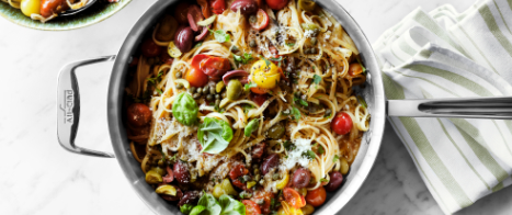 A pan of pasta with spinach, tomatoes and olives