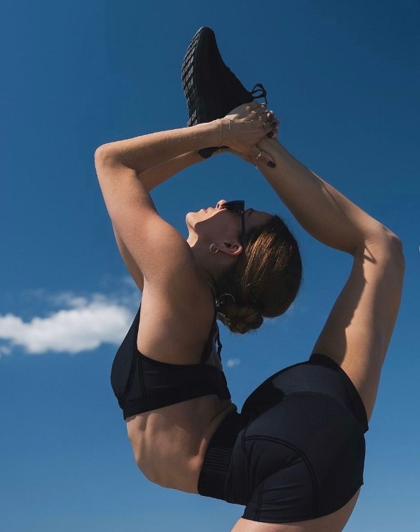 A woman in a yoga pose wearing yoga apparel from Alo 