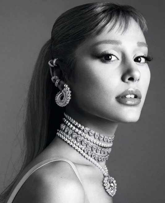 A black and white image of Ariana Grande wearing Swarovski jewelry