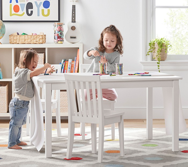 Two little girls doing crafts at a white table