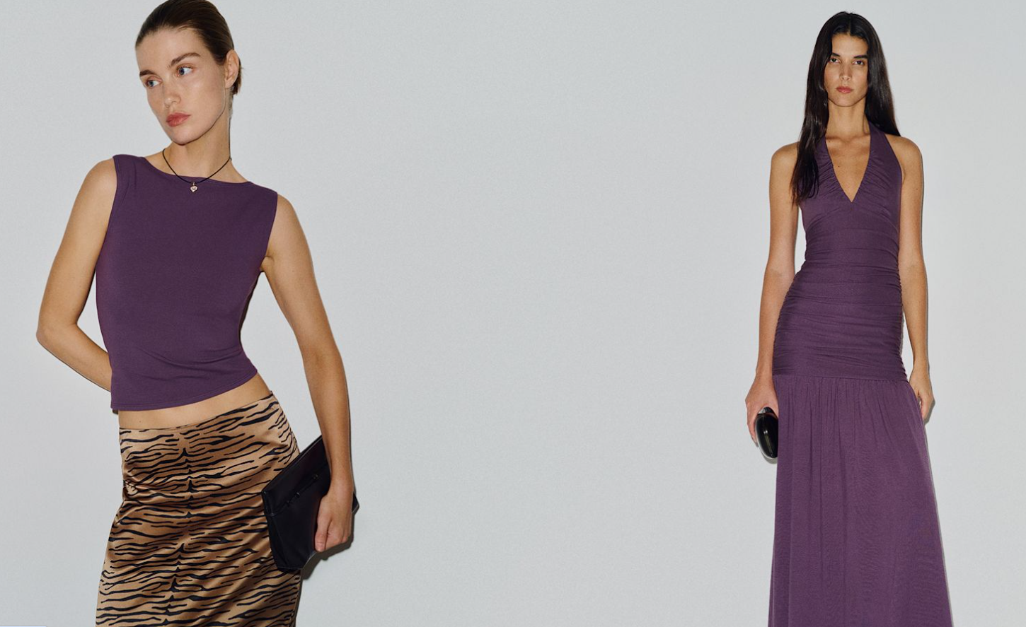 A woman wearing a burgundy tank and animal print skirt, standing next to a woman in a long burgundy maxi dress holding a black clutch