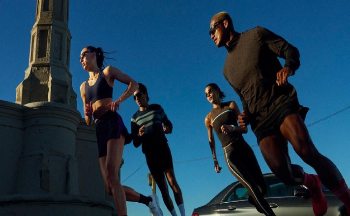 A group of people running with against a city backdrop