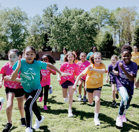 A group of girls running on the grass