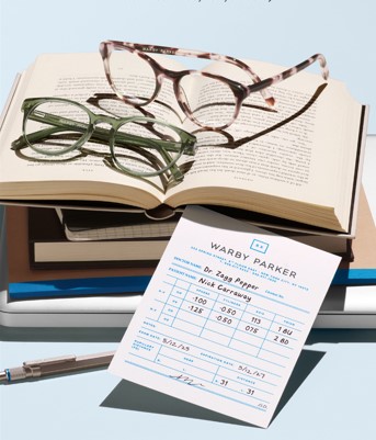 Warby Parker glasses resting on stacked books
