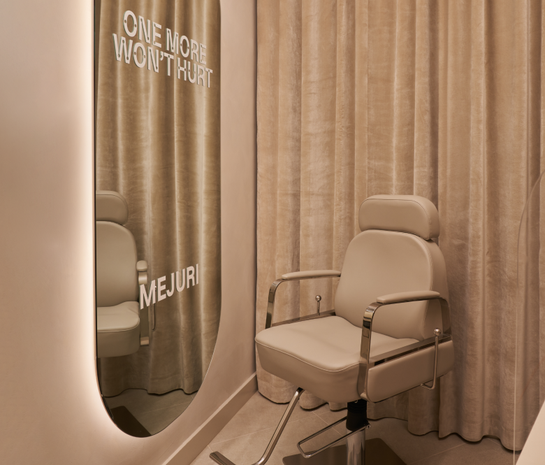 a private area with a seat and full sized mirror for customers to get their piercing done.