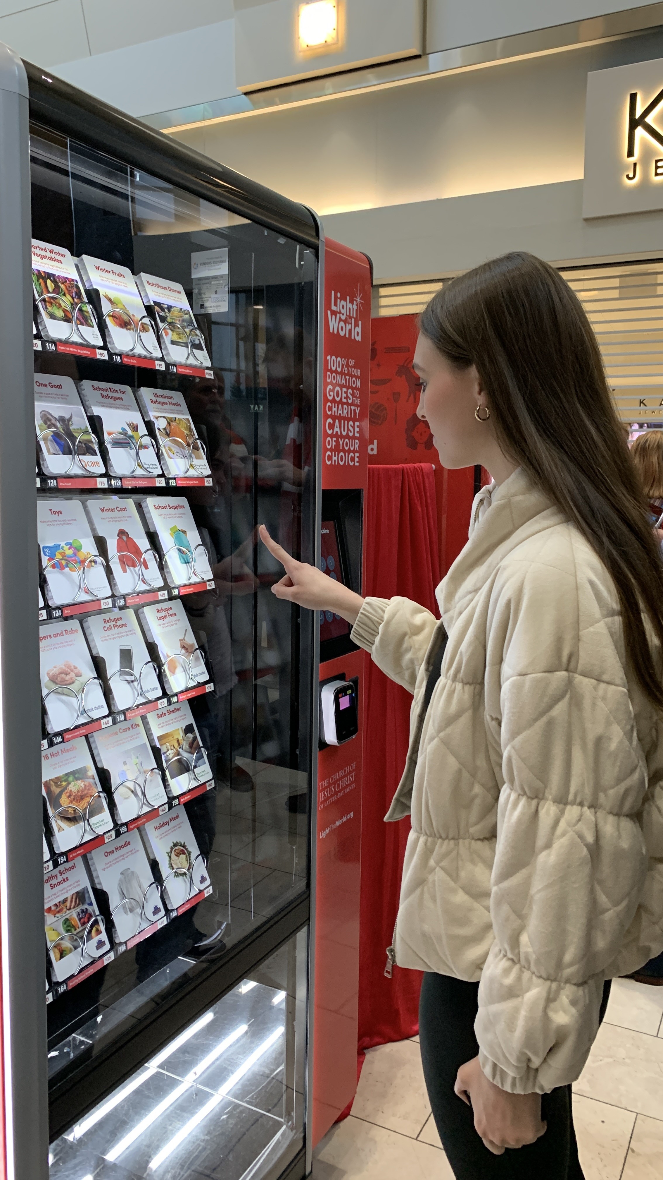 a young girl buying a charity item from a Giving Machine charity vending machine