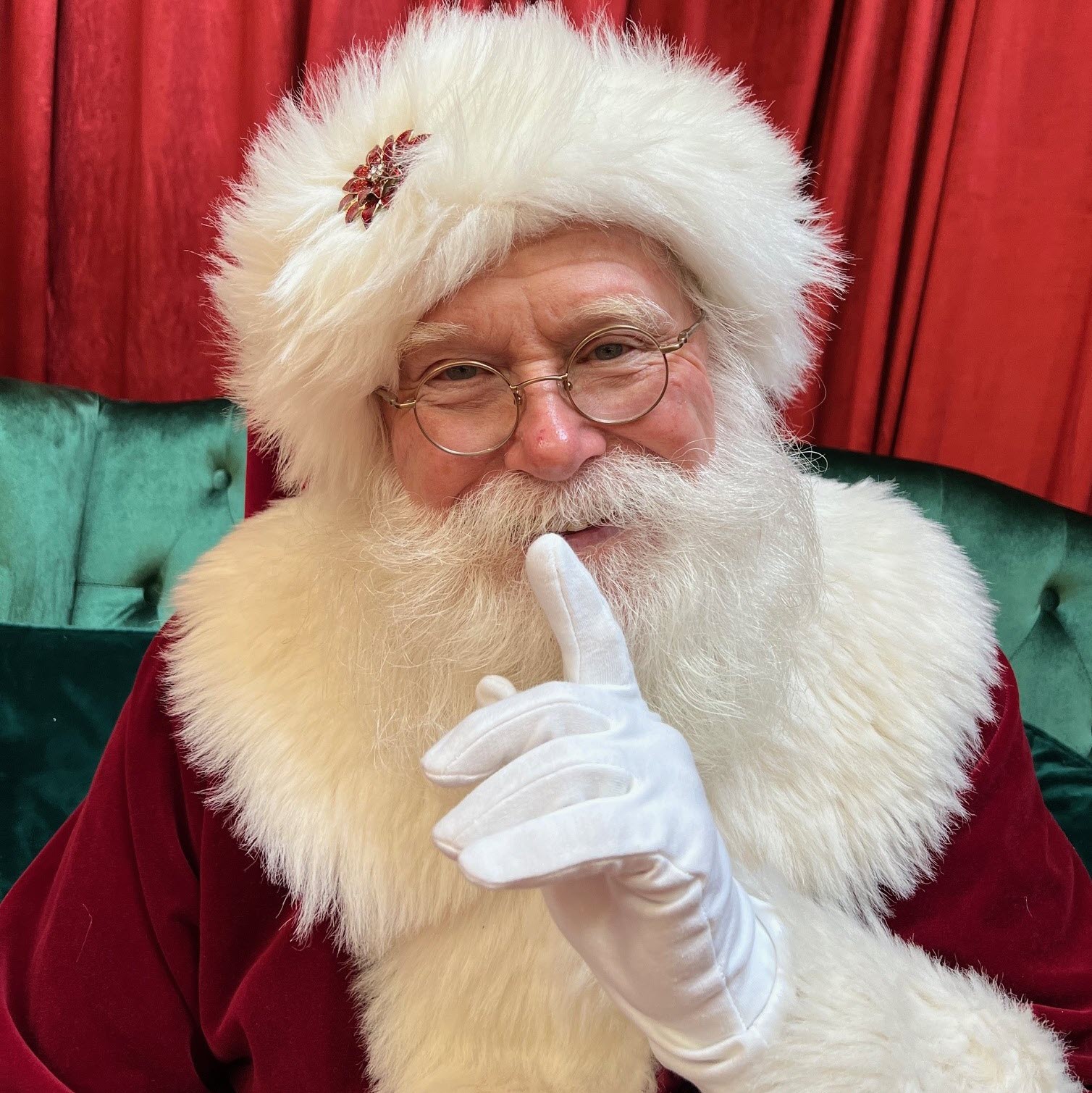 An image of Santa making a sign for quiet