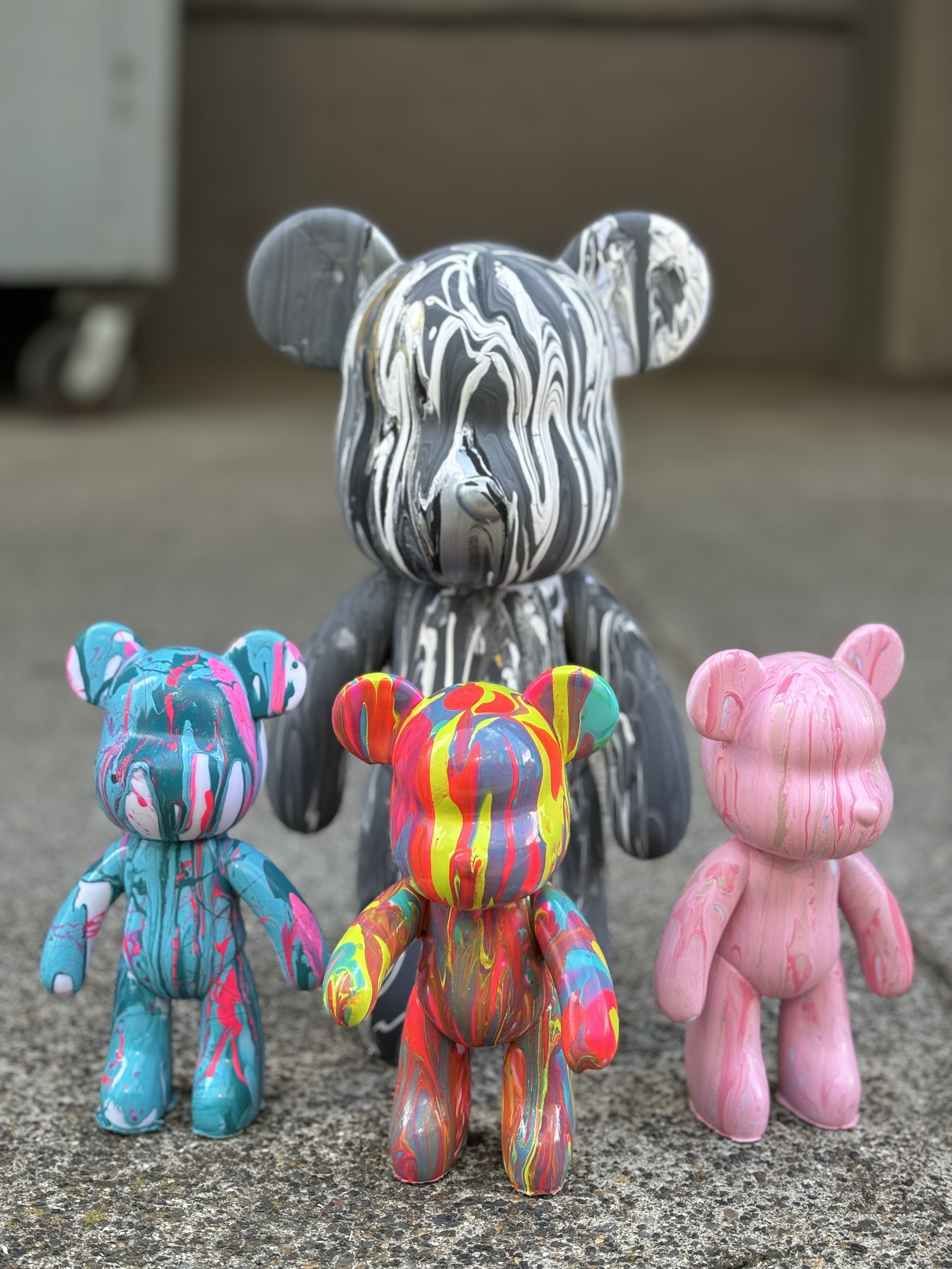 a picture of four plastic toy bears with dripping paint