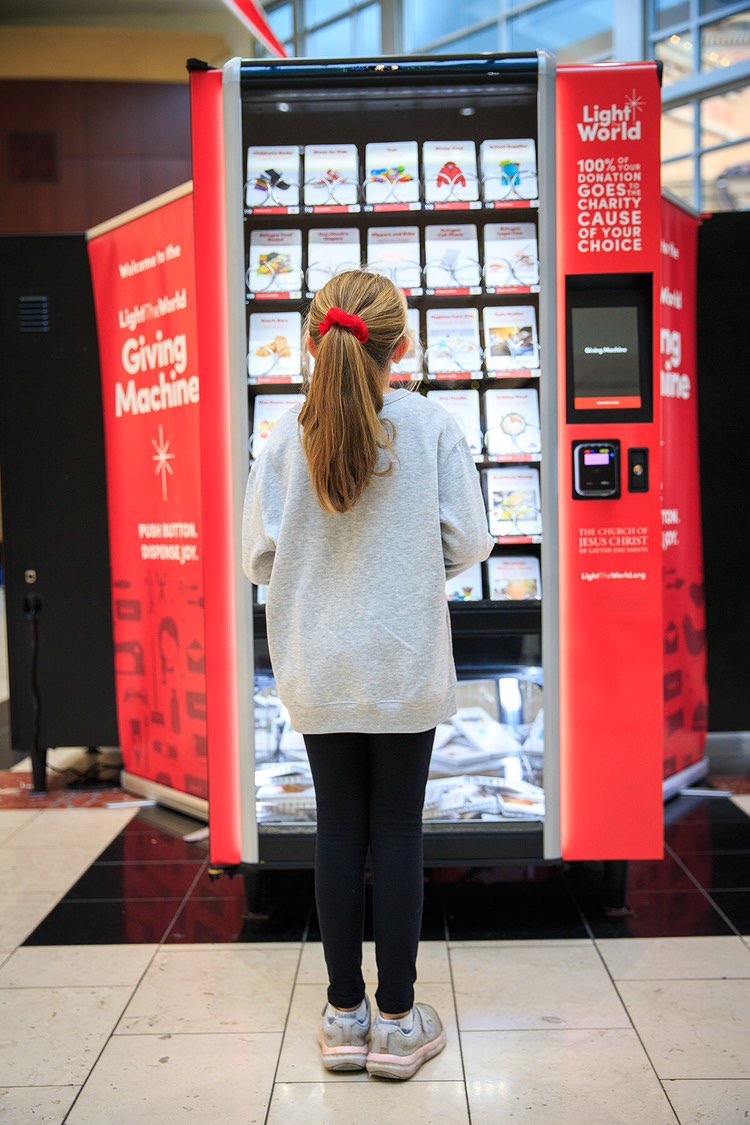a girl standing in front of a Giving Machine