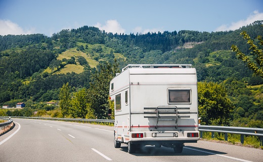 RV driving on the road with green landscape