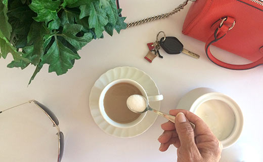 overhead pic of coffee, purse, plant, keys and sunglasses
