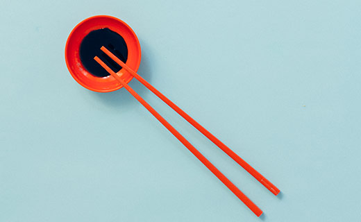 Red Chopsticks with a bowl of soy sauce.