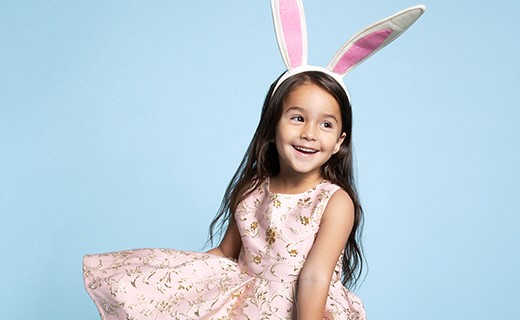 Young girl in pink dress and bunny ears