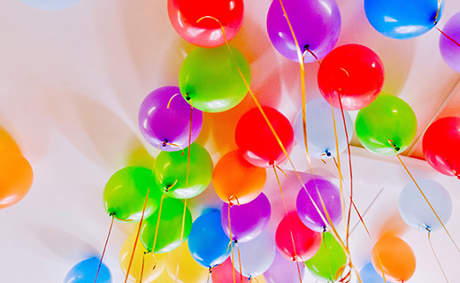 An assortment of colorful balloons in green, purple, red, blue, orange and yellow