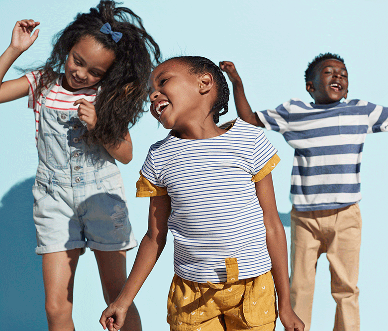 three kids jumping and smiling