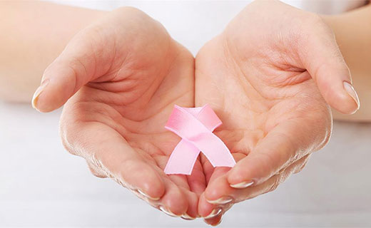 two hands holding a pink ribbon