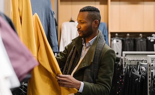 man looking at clothes in store