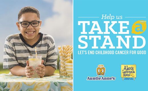 Boy sitting at table smiling holding glass of lemonade. Copy: Help us take a stand. Let's end childhood cancer for good. Auntie Anne's logo. Alex's Lemonade Stand logo.