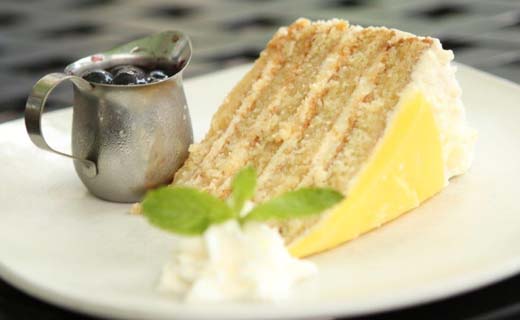 Big Daddy Lemon Cake with side of blueberry sauce, whipped cream and mint sprig.