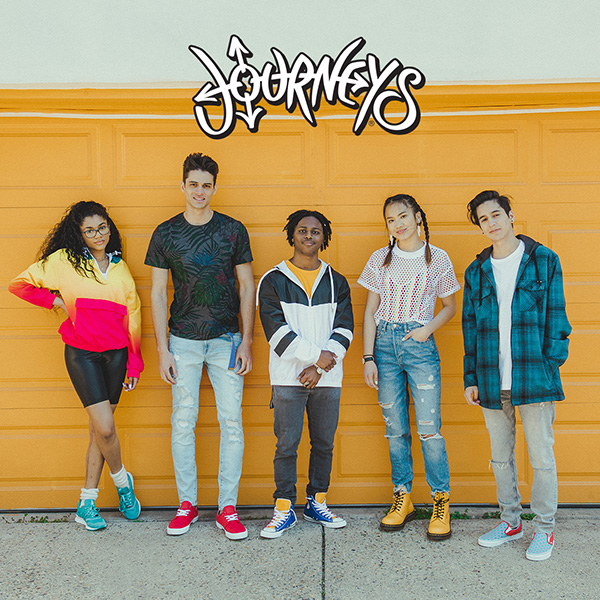 Journeys logo. Five individuals standing together wearing bright colored shoes and clothing.