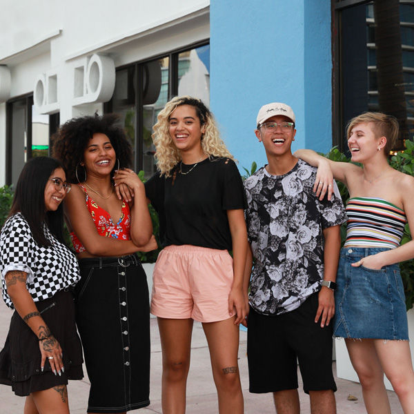 A group of stylish young people wearing casual outfits and laughing