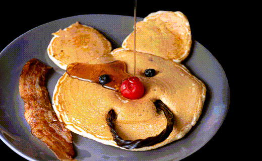pancake with fruit smiley face, syrup and bacon