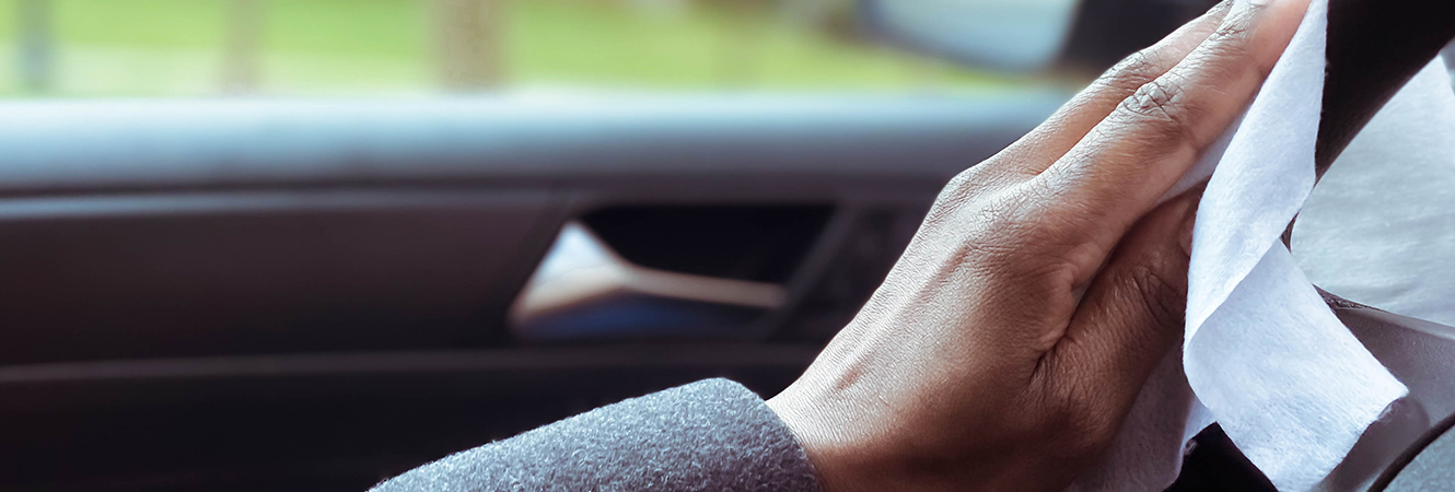 Person cleaning steering wheel