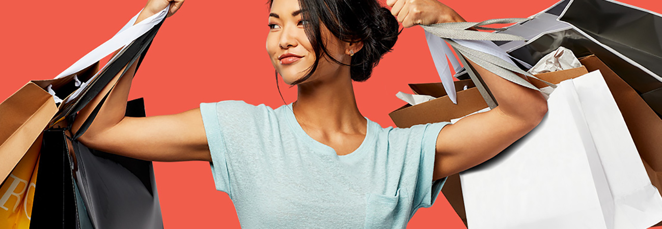 Woman holding up many shopping bags in each hand