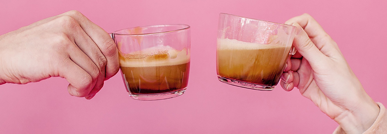 Two hands giving a toast with cappuccinos