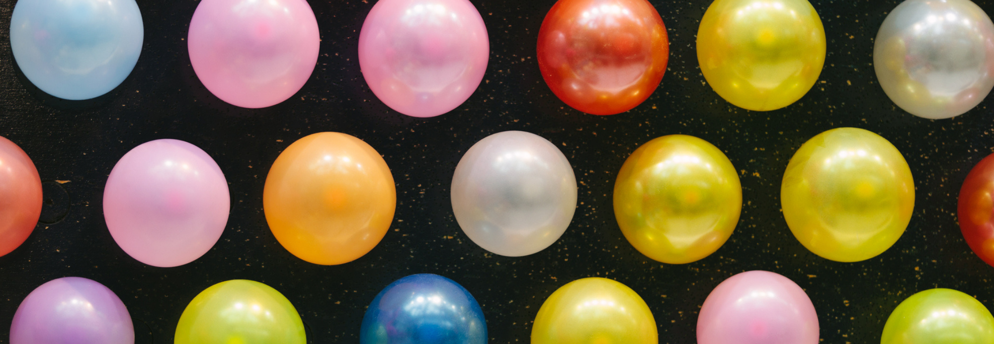 Rows of colorful balloons on a black background