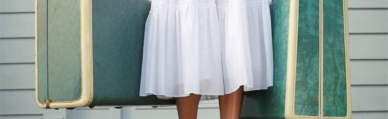 girl in white skirt holding blue vintage suitcases