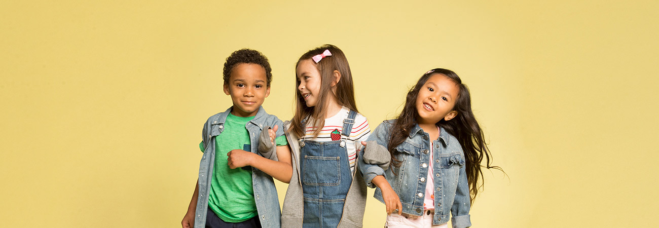 3 elementary school kids standing arm-in-arm