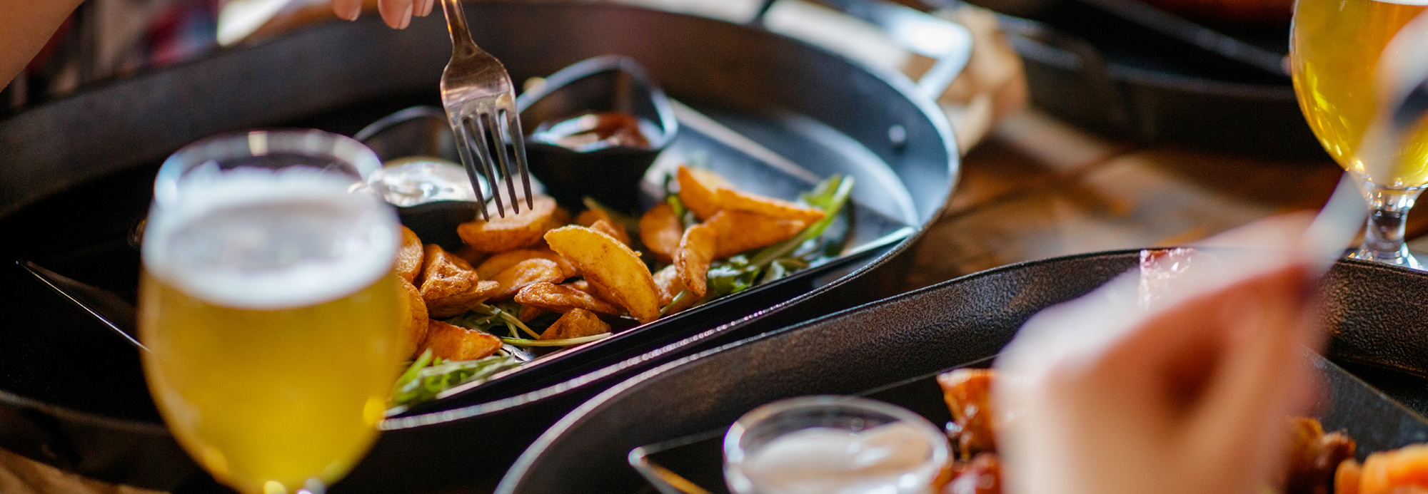 Diners enjoying plates of food and beverages