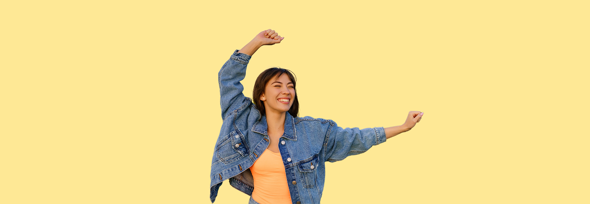 A young woman dancing and wearing a jean jacket