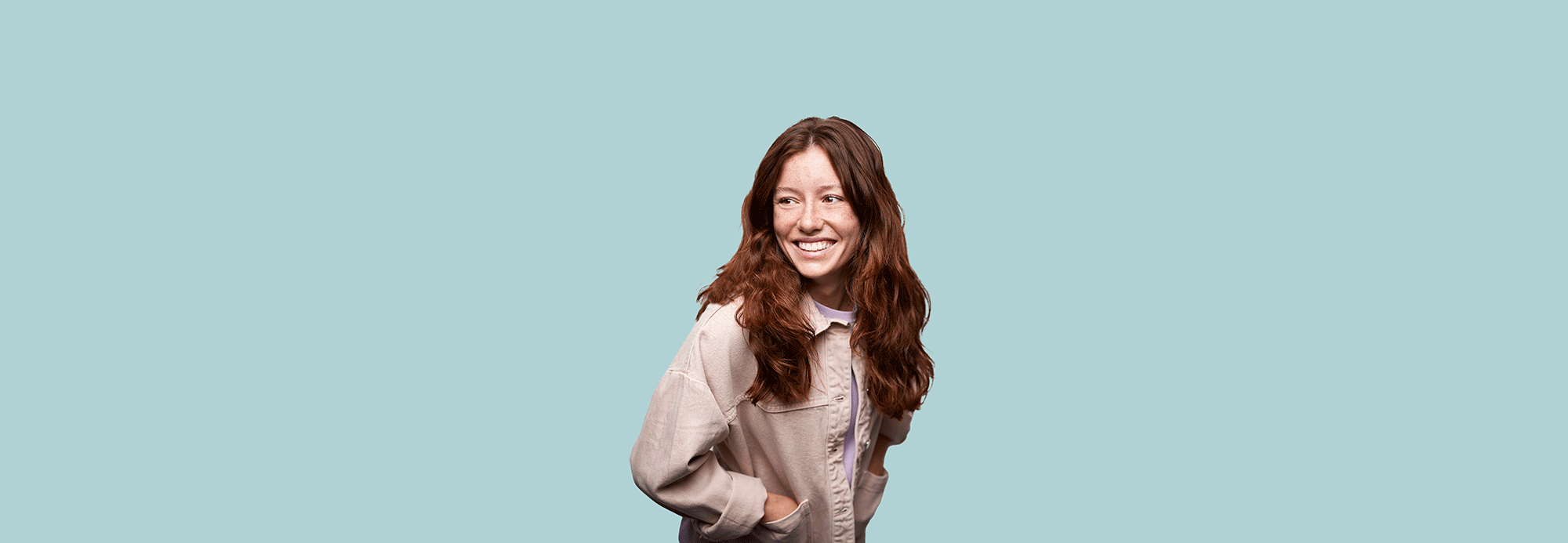 A smiling woman wearing a pink jean jacket