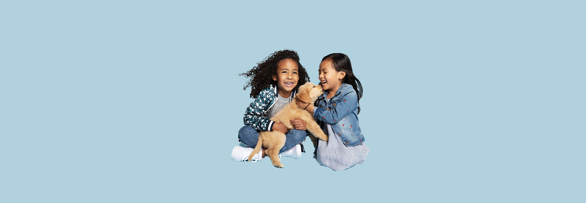 Two girls holding a puppy