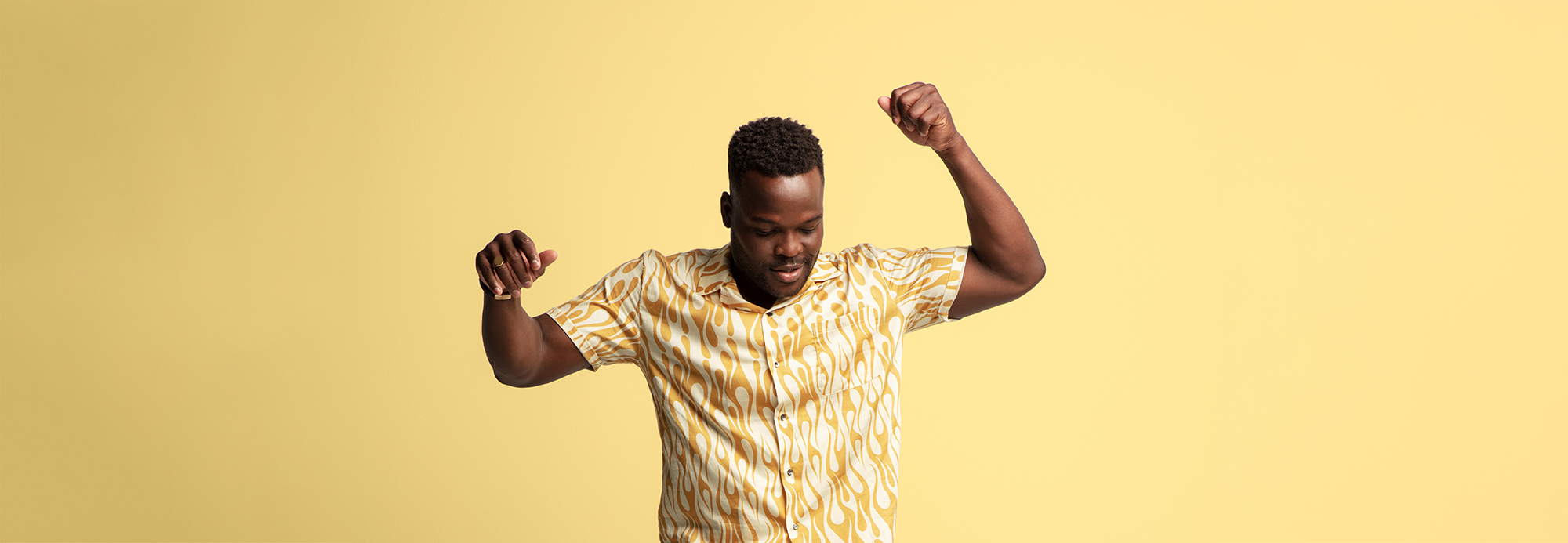 A man modeling a short sleeved shirt with a yellow and white flame pattern on it