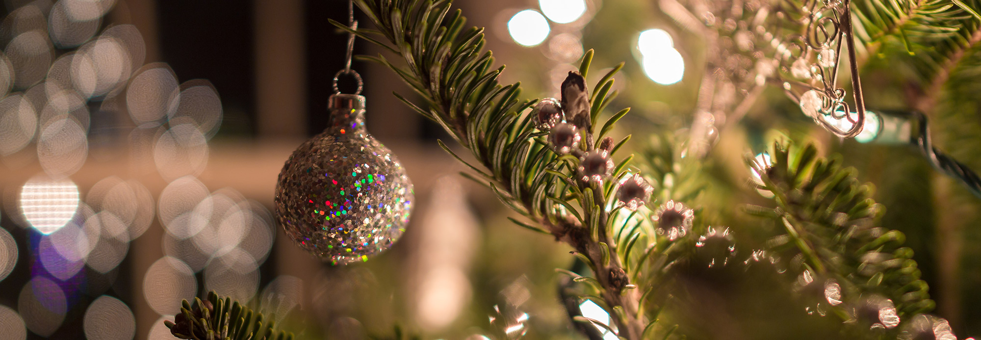 Silver ornaments and white lights on a tree