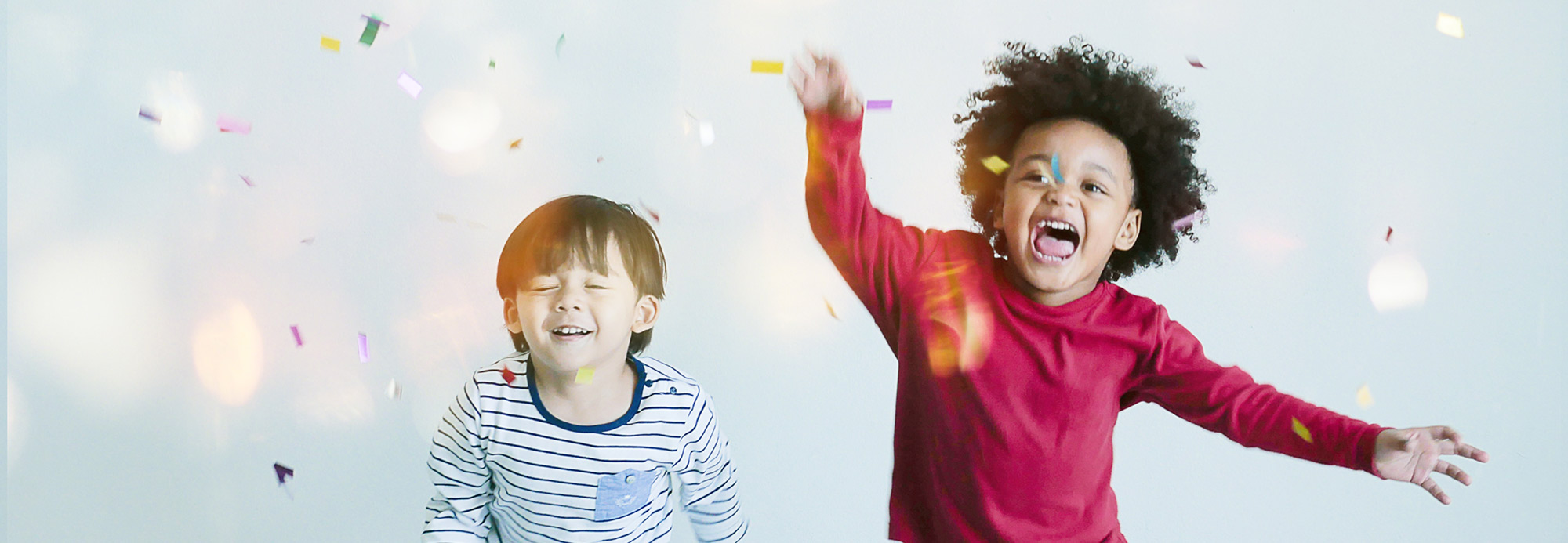 Two kids running through confetti