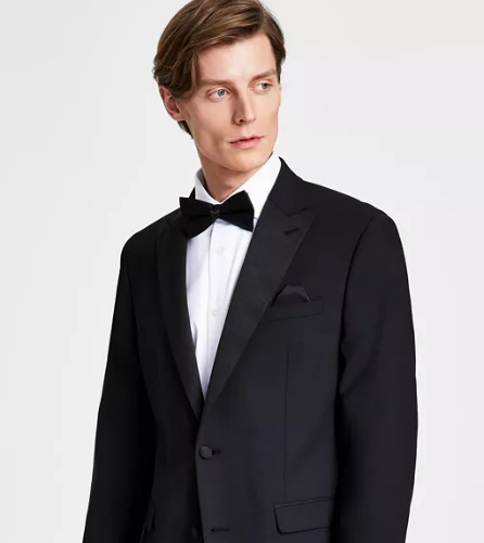 Man in tuxedo standing on white background
