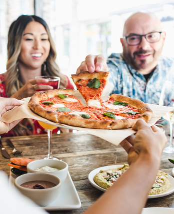 People sharing True Food pizza