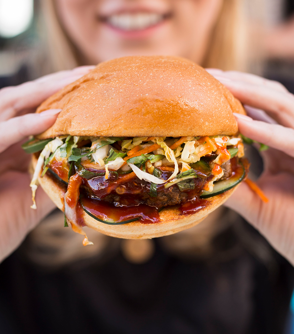 Woman about to take bite of large burger