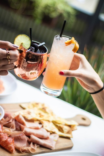 Cocktails cheersing over charcuterie